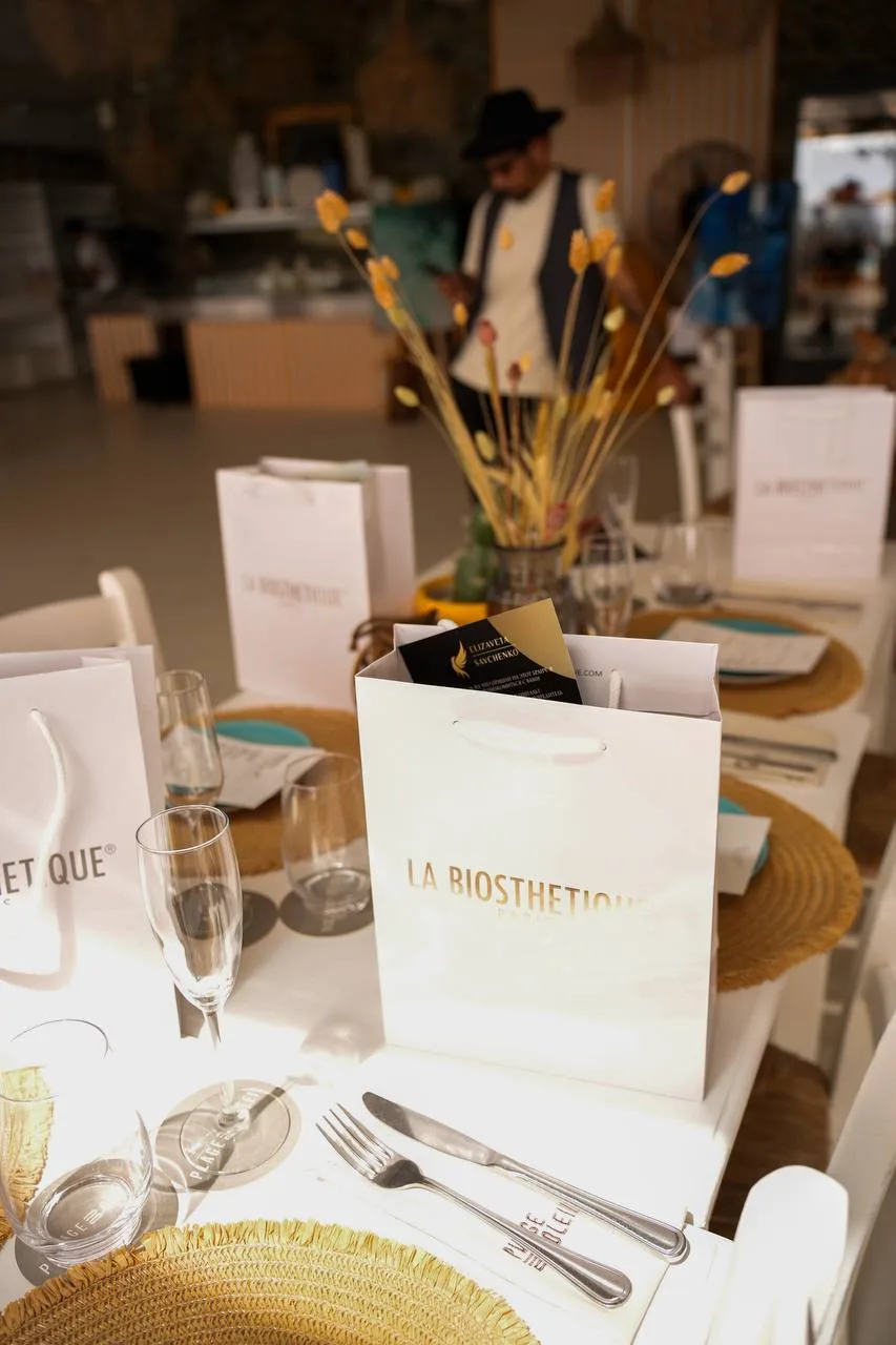 Warm private dining table with partner gifts, glassware and soft event styling
